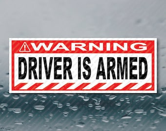 May include: Red and white warning sign with black text that reads "WARNING DRIVER IS ARMED".