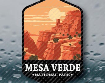 May include: A sticker featuring a Mesa Verde National Park design. The image shows a landscape with red rock formations, a setting sun, and the text "MESA VERDE NATIONAL PARK" in white.