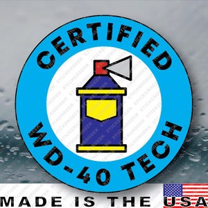 May include: A circular sticker featuring a blue border with the black text CERTIFIED WD-40 TECH. The center displays a graphic of a blue spray can with a red nozzle, a yellow label, and a yellow base, emitting a gray spray cone to the right.