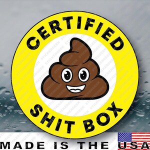 May include: A circular sticker with a bright yellow border and a white center. The text "CERTIFIED" is printed in black along the top curve, and "SHIT BOX" is printed in black along the bottom curve. A brown cartoon poop emoji is in the center.