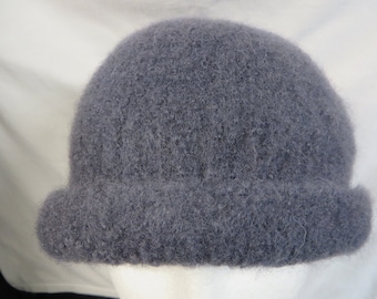 May include: A gray knitted hat with a wide brim. The hat is made of a soft, fuzzy yarn.