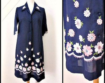 May include: A navy blue dress with a button-up front and short sleeves. The dress is embroidered with pink and white flowers.