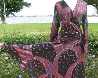May include: A long black and pink patterned wrap dress with long sleeves. The dress has a V-neckline and a flowing skirt.