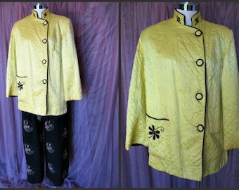 May include: A yellow quilted jacket with black trim and buttons. The jacket has a mandarin collar and a floral design on the pocket.