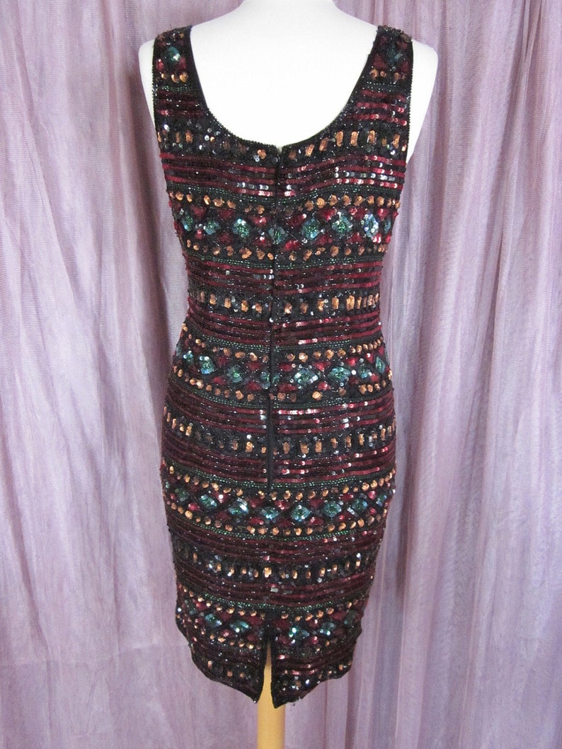 Puede incluir: Un vestido sin mangas de lentejuelas con un patr&oacute;n geom&eacute;trico en tonos negro, burdeos, dorado y turquesa. El vestido tiene una cremallera en la espalda y una abertura en la espalda.