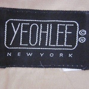 May include: Black label with white stitching that reads "YEOLLEE NEW YORK" in a rectangular shape.