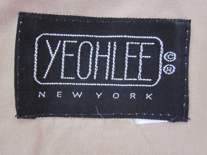 May include: Black label with white stitching that reads "YEOLLEE NEW YORK" in a rectangular shape.