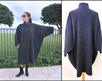 May include: A long, dark gray wool coat with a button-up front and a relaxed fit. The coat has a high collar and long sleeves.