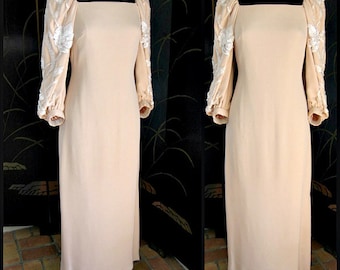 May include: A long, cream-colored dress with a square neckline and long sleeves. The sleeves have white floral embellishments.