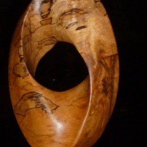 Large Mobius Strip. Oval Eye, hand carved vertically mounted mobius on steel base