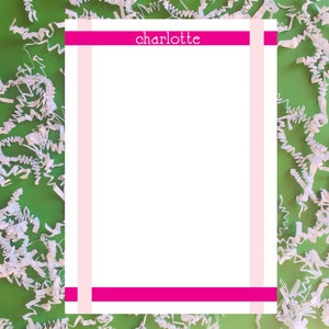 May include: A white sheet of paper with a pink and magenta border. The word "charlotte" is printed in black at the top of the page.