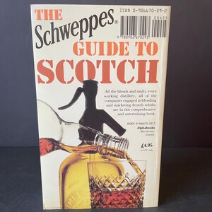 May include: A book titled "The Schweppes Guide to Scotch" with a cover featuring a bottle pouring into a glass. The cover has orange and white text. The book's spine shows the ISBN and price.