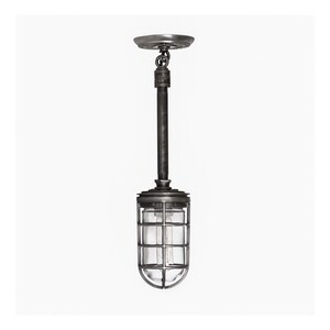 A rustic industrial pendant light with a metal cage and glowing bulb