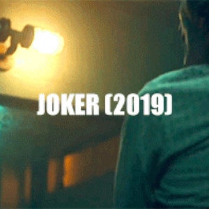 Film still screenshot from the 2019 movie Joker displaying Arthur Fleck in the gritty public bathroom scene, illuminated by a rustic double cage industrial wall sconce prop fixture handmade by MillerLights®.