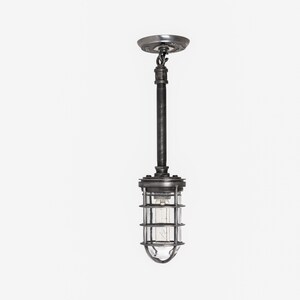 Industrial hanging light with a protective metal cage and warm bulb glow