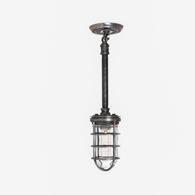 Industrial hanging light with a protective metal cage and warm bulb glow
