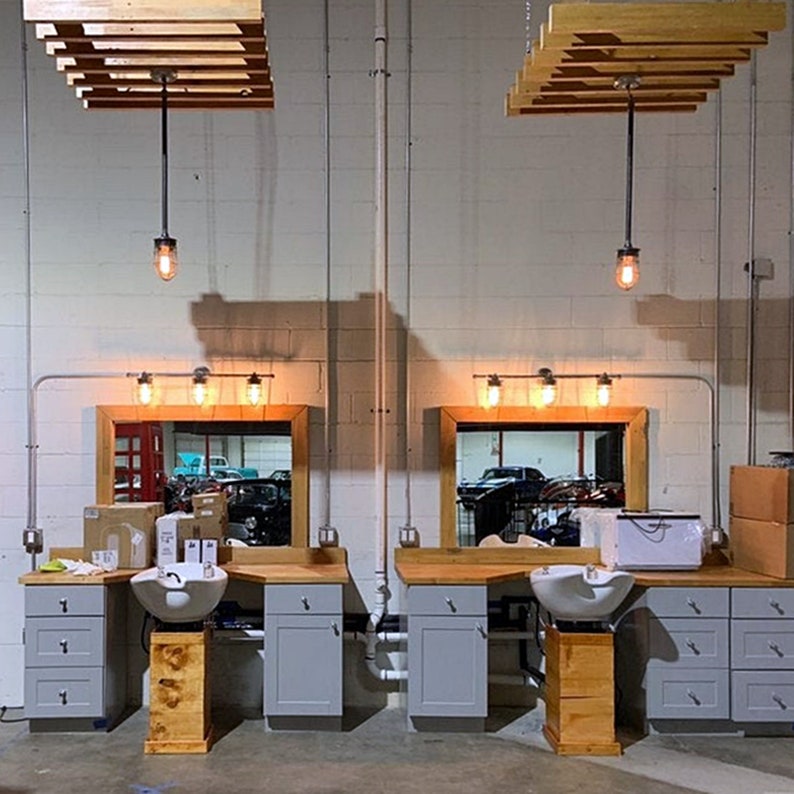A vintage industrial pendant light with a metal cage and glowing bulb, hanging elegantly in a spacious salon