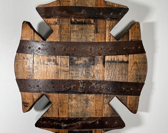 May include: A wooden wall decor in the shape of a fire department cross. The cross is made of reclaimed wood planks and has metal bands and rivets.