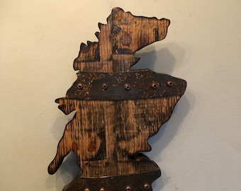 Puede incluir: Una decoración de pared de madera con forma de mapa de Irlanda. El mapa está hecho de madera reciclada y tiene un acabado marrón rústico. El mapa está acentuado con remaches de cobre.