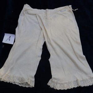 May include: A pair of white cotton underwear with lace trim. The underwear has a split in the front and back.