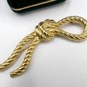 Vintage marked SNK gold tone rope pin brooch