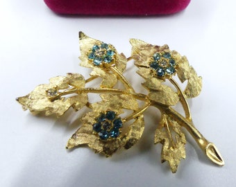 Broche vintage de los años 60 en tono dorado y forma de hoja de pedrería azul