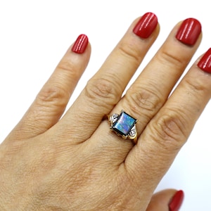 May include: A gold ring with a rectangular black opal gemstone and two small diamonds on the band.