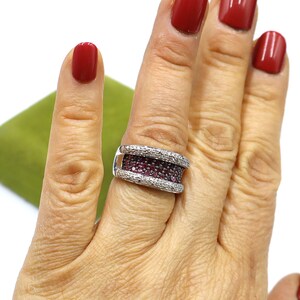 May include: A silver ring with a double band of pave set pink and white stones.