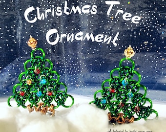 May include: Two green Christmas tree ornaments made of metal rings, decorated with red and blue beads. The ornaments are sitting on a white surface with a blue and white starry background. The text "Christmas Tree Ornament" is written in white on the background.  A tutorial to build your own Christmas tree out of little metal rings.