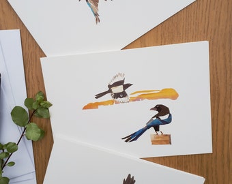 May include: Three cards with different bird illustrations. The top card features a blue and brown bird in flight against a green background. The middle card shows a black and white bird with a yellow background. The bottom card has a black bird in flight against a yellow and orange background.