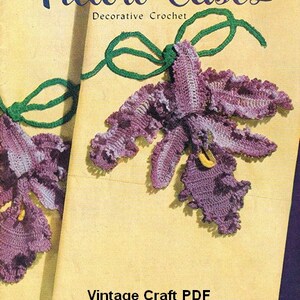 May include: Vintage craft pattern booklet for crocheting pillow cases with a purple and green orchid design. The cover features the text "Pillow Cases Decorative Crochet" and "Book No. 264".