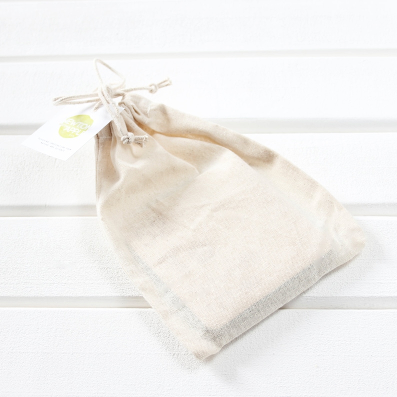 May include: A white cotton drawstring bag with a small green and white label that says "eco friendly".