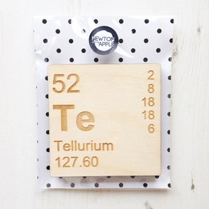 May include: A wooden block featuring the periodic table element Tellurium (Te). The block is light brown and displays the atomic number 52, the symbol Te, the name Tellurium, and the atomic weight 127.60.
