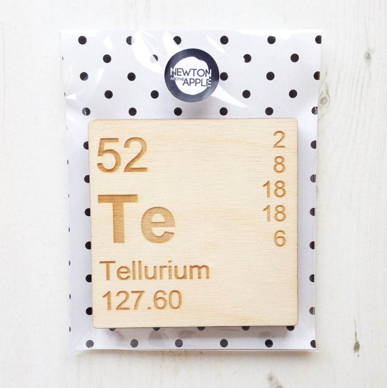 May include: A wooden block featuring the periodic table element Tellurium (Te). The block is light brown and displays the atomic number 52, the symbol Te, the name Tellurium, and the atomic weight 127.60.
