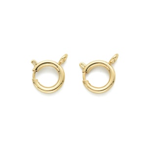 Puede incluir: Dos cierres redondos de metal dorado con cierre de resorte. Los cierres están diseñados para usarse para sujetar joyas u otros artículos.