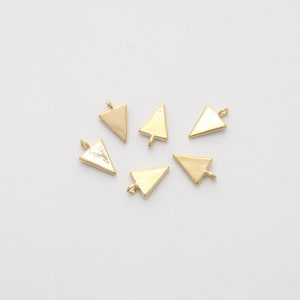 May include: Six gold triangle charms with a loop at the top. The charms are flat and have a shiny finish.