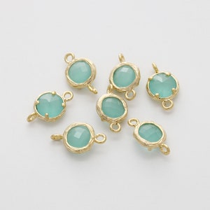May include: Seven gold-toned metal connector charms with light blue glass stones. Each charm has two loops for attaching to jewelry.