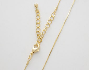 May include: A gold chain necklace with a lobster clasp and an extender chain. The chain is made of small, delicate links.