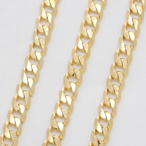 May include: Three gold chains with a curb link pattern. The chains are laid out in parallel lines on a white background.