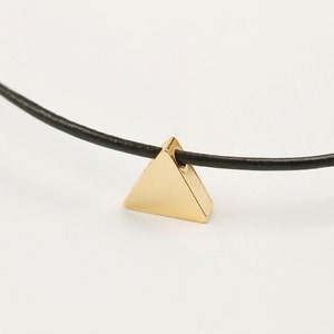 May include: A gold triangle pendant necklace on a black leather cord.