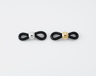 May include: Two black rubber eyeglass holders with a loop design. One holder has a silver bead and the other has a gold bead.
