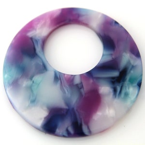 May include: A round, white, blue, and purple marbled plastic pendant with a large hole in the center.