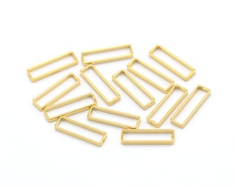 May include: A group of gold-colored metal rectangular jump rings. The rings are arranged in a random pattern on a white background.