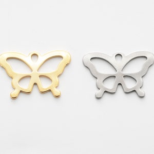 Puede incluir: Dos abalorios de metal en forma de mariposa, uno dorado y otro plateado. Los abalorios est&aacute;n recortados en forma de mariposa con alas delicadas.