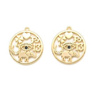 May include: Two gold-colored charm pendants with a circular design. Each pendant features a heart, a four-leaf clover, an eye, a horseshoe, an elephant, and the number 13. The eye has a black center. The pendants are on a white background.