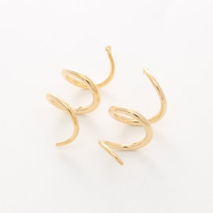 May include: Two pairs of gold-toned spiral hoop earrings. Each earring is made of a single piece of metal that is twisted into a spiral shape.
