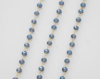 May include: Three strands of a blue crystal beaded necklace with gold chain links.