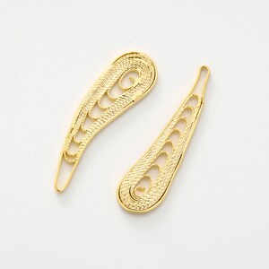 May include: Two gold filigree earrings in the shape of a teardrop with a swirl at the top.