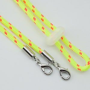 May include: A yellow and red lanyard with silver clasps and a clear plastic slider.