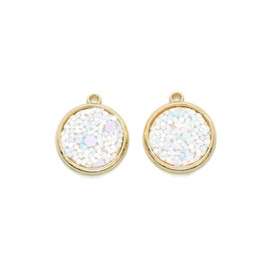 May include: Two gold-toned round charms with a white glitter finish. Each charm has a small loop at the top for attaching to jewelry.